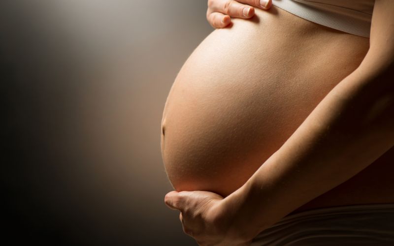 barriga de mujer embarazada arropada por sus manos